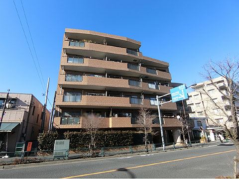 現地外観写真　マンションの隣接交番と八百屋さん